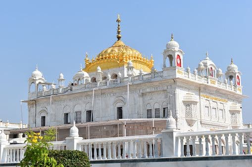 Gurdwara Langar Sahib illuminated at night, reflected in the sarovar